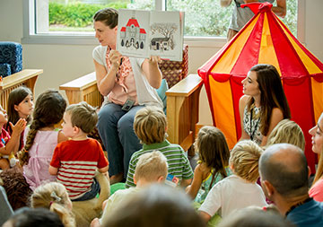 Photo of a women reading a book to children. Links to Closely Held Business Stock Photo of a women reading a book to children. Links to Closely Held Business Stock